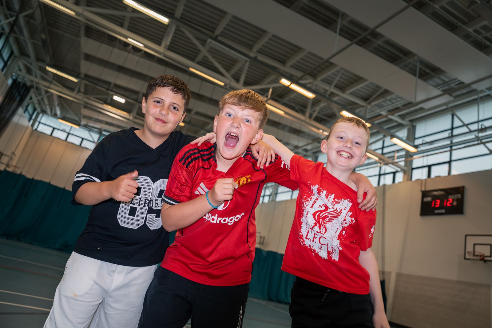 Three boys celebrating in the sports hall at PYC